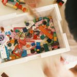 a child is playing with a box of legos